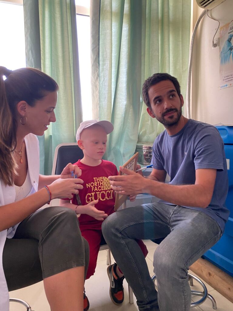 Dois profissionais da visão atendem uma criança pequena na consulta